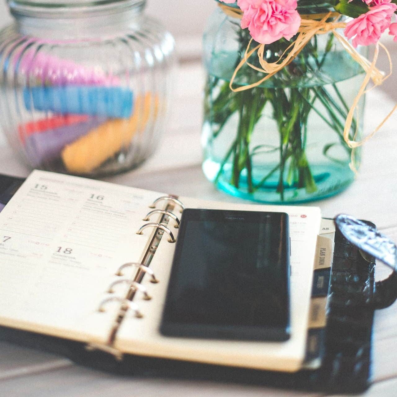 smartphone-925120_1920 Tisch mit einem Planner, einem Handy und Blumen